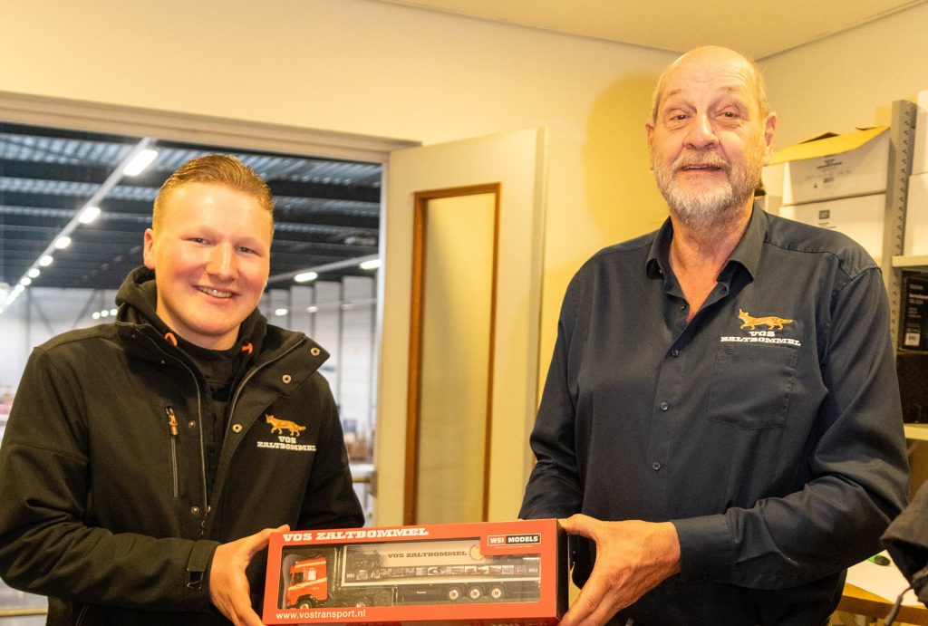 Een schaalmodel van een Vos Transport-truck wordt overhandigd.
